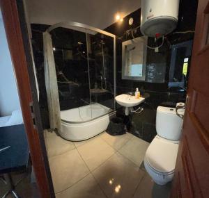 a bathroom with a tub and a toilet and a sink at Pokoje Gościnne Pocztacaffe in Gdynia