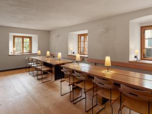 a room with wooden tables and chairs and windows at berge I Design-Quartiere in Aschau im Chiemgau