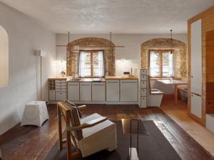 a large kitchen with white cabinets and a sink at berge I Design-Quartiere in Aschau im Chiemgau +133 photos