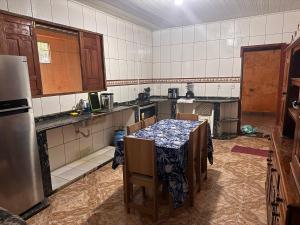 a kitchen with a table and chairs in it at Casa com Quartos compartilhados in Rio Branco
