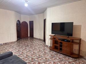 a living room with a flat screen tv on a entertainment center at Casa com Quartos compartilhados in Rio Branco