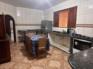 a kitchen with a table with chairs and a refrigerator at Casa com Quartos compartilhados in Rio Branco +7 photos
