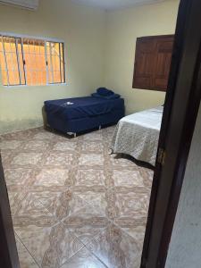 a room with two beds and a tiled floor at Casa com Quartos compartilhados in Rio Branco