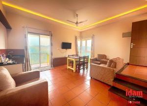 a living room with two couches and a table at Idam Resort in Vagamon