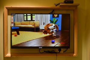 a television with a dog on it in a living room at Shri Guru Prasad in Belgaum