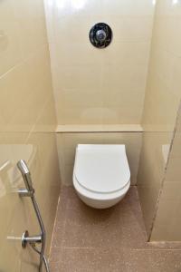 a white toilet in a bathroom with a shower at Shri Guru Prasad in Belgaum