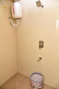 a bathroom with a toilet and a phone on the wall at Shri Guru Prasad in Belgaum