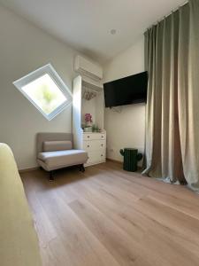 a living room with a chair and a television at ComfortHouse AlbatrosMare in Ladispoli