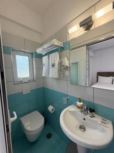 a bathroom with a sink and a toilet and a mirror at Himara Royal Hotel in Himare +76 photos
