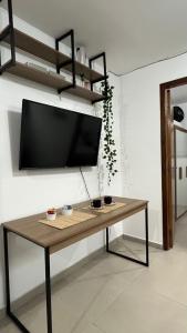 a table in a room with a tv on a wall at Apartamento Completo No Centro de Taboão da Serra in Taboão da Serra