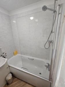 a bathroom with a shower and a bath tub at Holly Cottage in Edwinstowe +7 photos