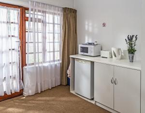 una cocina con microondas en una encimera junto a una ventana en Summer Blue Guesthouse, en Port Elizabeth 17 fotos más