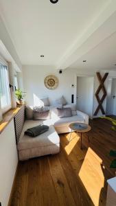 a living room with a couch and a table at Klimatisierte Komfort-Eifel-Ferienwohnung Mechernich, Obergartzem, Satzvey - nahe Krewelshof, Burg Satzvey & Phantasialand in Mechernich
