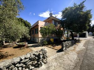 a house with a stone wall in front of it at Villa Mario Verde in Punat