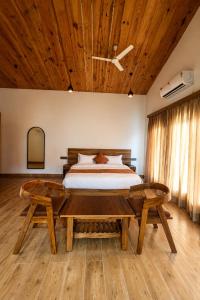a bedroom with a bed and a wooden ceiling at Corbett Retreat in Rāmnagar +17 photos