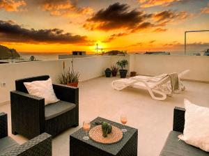 a balcony with a sunset on the horizon at Sunset Terrace Studio - Ocean View - Top Floor in Buenavista del Norte