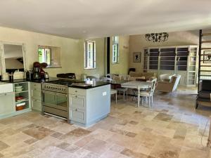 a kitchen and dining room with a table and a stove at La croix des granges - le gîte in Chapdeuil