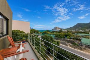 a balcony with a view of the ocean and mountains at LA HACIENDA - MODERN, BRIGHT, STYLISH House with Private Pool in Cape Town
