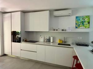 a white kitchen with white cabinets and a counter at Ankaran Studio Escape in Ankaran