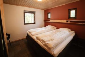 a bedroom with a large bed with white sheets at Käenpesän Aihki in Syöte