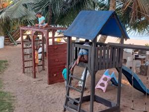 two children playing on a playground on the beach at Hotel Palm Rock Beach in San-Pédro