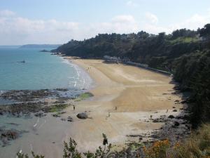 a beach with people walking on the sand and the water at Tagar'étape in Étables-sur-Mer