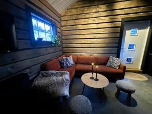 a living room with a couch and a table at Log cabin in Hodlekve with mountain view in Sogndal