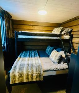 a bedroom with two bunk beds in a cabin at Log cabin in Hodlekve with mountain view in Sogndal