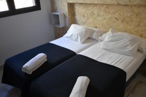 1 dormitorio con 1 cama con toallas en Apartamentos Gorbea Suites, en Sierra Nevada