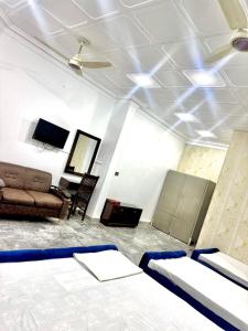a room with two beds and a couch at Hotel Royal Luxury Multan in Multan +34 photos