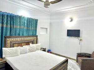 a bedroom with a bed and a tv on the wall at Hotel Royal Luxury Multan in Multan