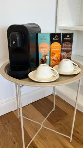 a table with two plates and a coffee maker and books at Alpine Loft in Kapfenberg