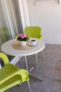 a table and chairs with a cup of coffee and flowers at Giray Butik Hotel in Alanya +29 photos