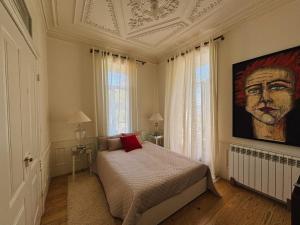 a bedroom with a bed with a painting on the wall at Casal do Arcebispado in Felgueiras