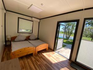 a room with a bed and a sliding glass door at Naturerlebnis Schlafcontainer auf dem Bauernhof in Leutershausen