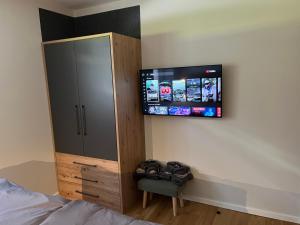 a bedroom with a cabinet and a tv on the wall at Ferienwohnung Heiterwang in Heiterwang