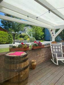a patio with a barrel and a white canopy at Ferienhaus Maar in Beckingen