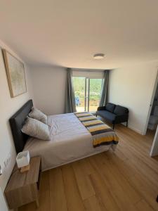 a bedroom with a bed and a chair and a window at Tossal del Pla in Estivella