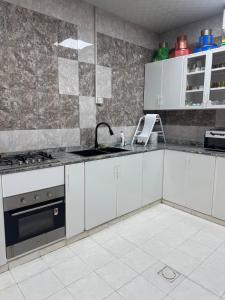 a kitchen with white cabinets and a sink at استراحة الصقر in Khor Fakkan +14 photos