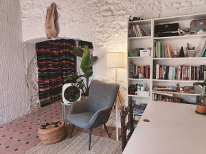 a living room with a chair and book shelves at Casa Barreres in Moncada