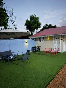 a yard with chairs and a pool and a house at Casa Nalya in Kourou
