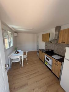 a kitchen with a white table and a white table and chairs at Tossal del Pla in Estivella