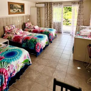 a room with three beds in it with a window at Rooi Bij de Knoptoren B&B in Sint-Oedenrode