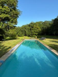 a large blue swimming pool in a yard at La croix des granges - le gîte in Chapdeuil