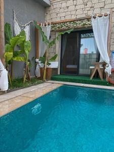 a blue swimming pool in front of a house at Chloe hotel Alaçatı in Alaçatı +149 photos