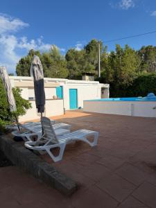 a pair of lounge chairs and an umbrella on a patio at Tossal del Pla in Estivella