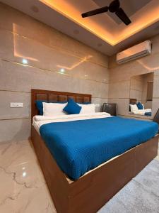 a bedroom with a bed with blue sheets and a ceiling at Oaktel Jagannath Dham in Vrindāvan +25 photos