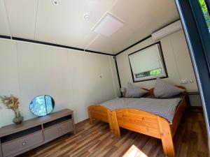 a bedroom in a tiny house with a bed and a window at Naturerlebnis-Schlafcontainer in Leutershausen