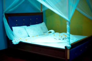 a bedroom with a bed with a blue canopy at Kilimanjaro Simba Lodge in Moshi