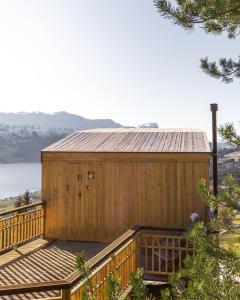 a wooden building on a deck with a view of the water at Engeset Trehytter in Vereide